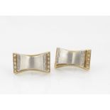 A pair of two coloured gold and diamond ear studs, satin finish with diamond terminals and gold