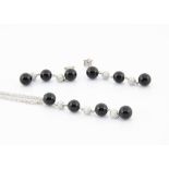 An 18ct white gold necklace and earring set, the three strand necklace supporting an onyx and