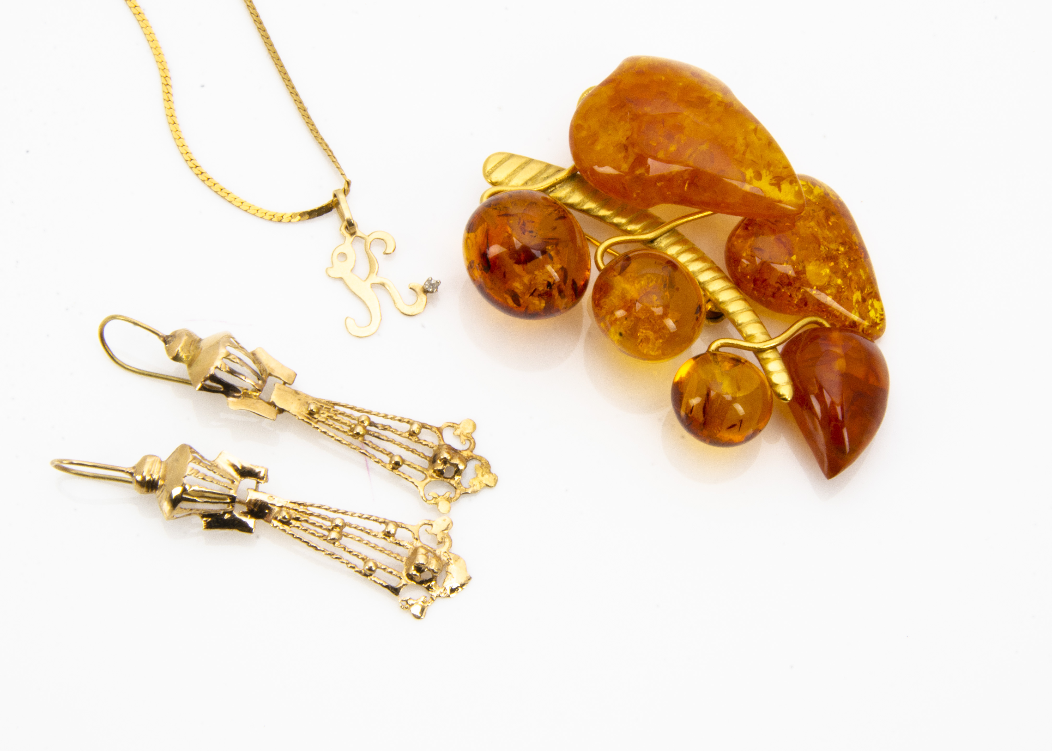A continental yellow metal and amber brooch, a pair of yellow metal earrings and necklace, total