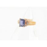 A 9ct gold iolite dress ring, the step cut in claw setting with scroll shoulders and tapered