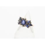 A sapphire and diamond dress ring, the oval mixed cut synthetic sapphire in four claw setting