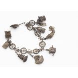 A Chinese silver charm bracelet, the stylised roundel links supporting eight charms including