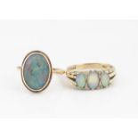 A 9ct gold three stone precious opal dress ring, the three oval cabochons alternatley set with eight