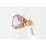 A 9ct gold amethyst ring, the oval cut in claw setting with heart pierced shoulders, ring size N,