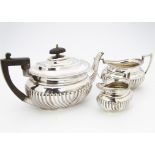 A late Victorian three piece silver tea set by Henry Wilkinson & Co, London 1899, fluted lower