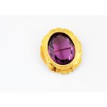 A 19th Century purple paste and yellow metal mounted brooch or pendant, the oval mixed cut in