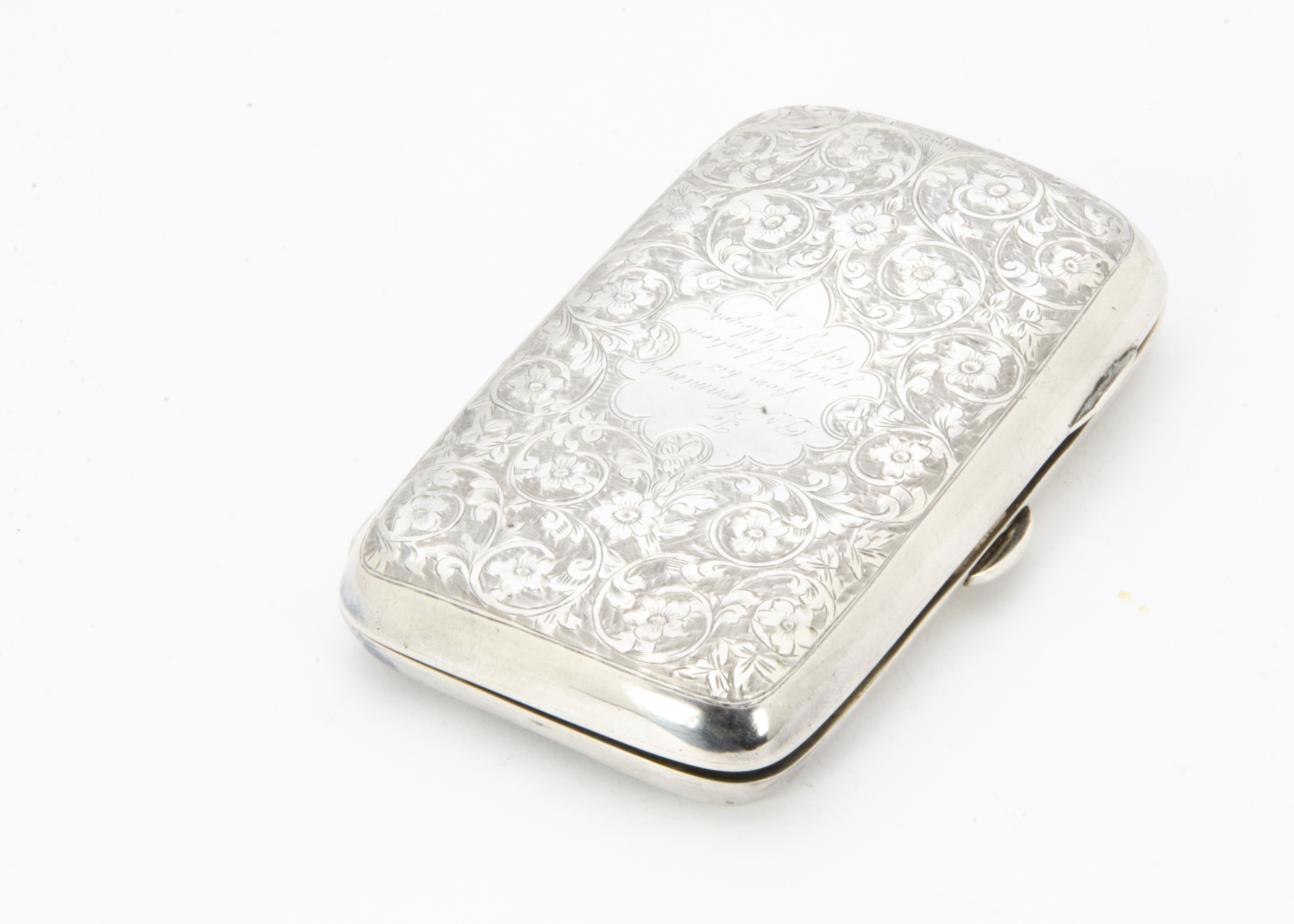 An Edwardian silver cigar case by TH, rectangular and curved with engraved scrolling foliage and