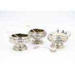A three piece Georgian style white metal cruet set, two trench salts and a mustardall with raised