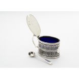 A George III silver mustard pot by T.H, oval with pierced sides, with a blue glass liner and similar