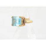 A contemporary topaz dress ring, the step cut blue topaz in a four claw setting with pierced gallery