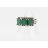 A continental emerald and diamond three stone dress ring, the square cut emeralds in four claw