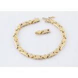 A lady's 14ct two colour gold diamond bracelet, the white metal batons alternately set with yellow