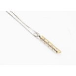 An 18ct two colour gold diamond pendant and chain, the brilliant cuts in tension setting on a fine