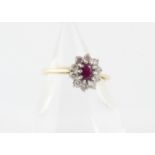 An 18ct gold ruby and diamond cluster ring, the oval mixed cut ruby claw set surrounded by brilliant