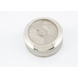 A modern silver plated perpetual desk calander by Cartier, circular with fluted sides, rotating