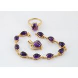 A modern amethyst suite, including a cabochon set amethyst ring in yellow 9ct gold, ring size Q, a