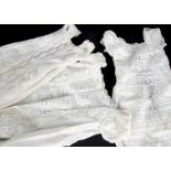 A collection of Children's dresses and nightgowns, including several white cotton cap-sleeved