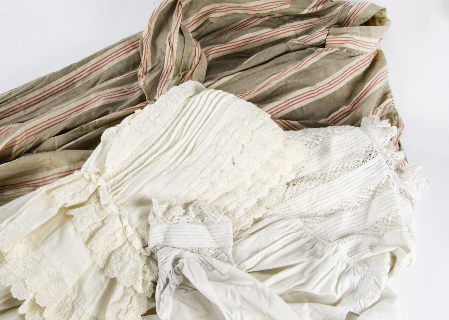 A collection of costume, including white cotton nightgowns, trimmed with pin tucking and lace, circa