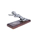 A Desmo leaping Jaguar mascot, mounted to wooden base, having white metal St Christopher plaque to