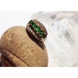 An emerald and diamond 14K marked dress ring, the five mixed round cut claw set graduated emeralds