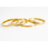 Four continental wheel engraved yellow metal bangles, marked 750, 56g