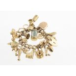 A 9ct gold flattened curb link and textured padlock clasp charm bracelet, with multiple gold charms,