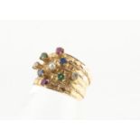 A continental yellow metal and multi gem set five band dress ring, set with rubies, sapphires,