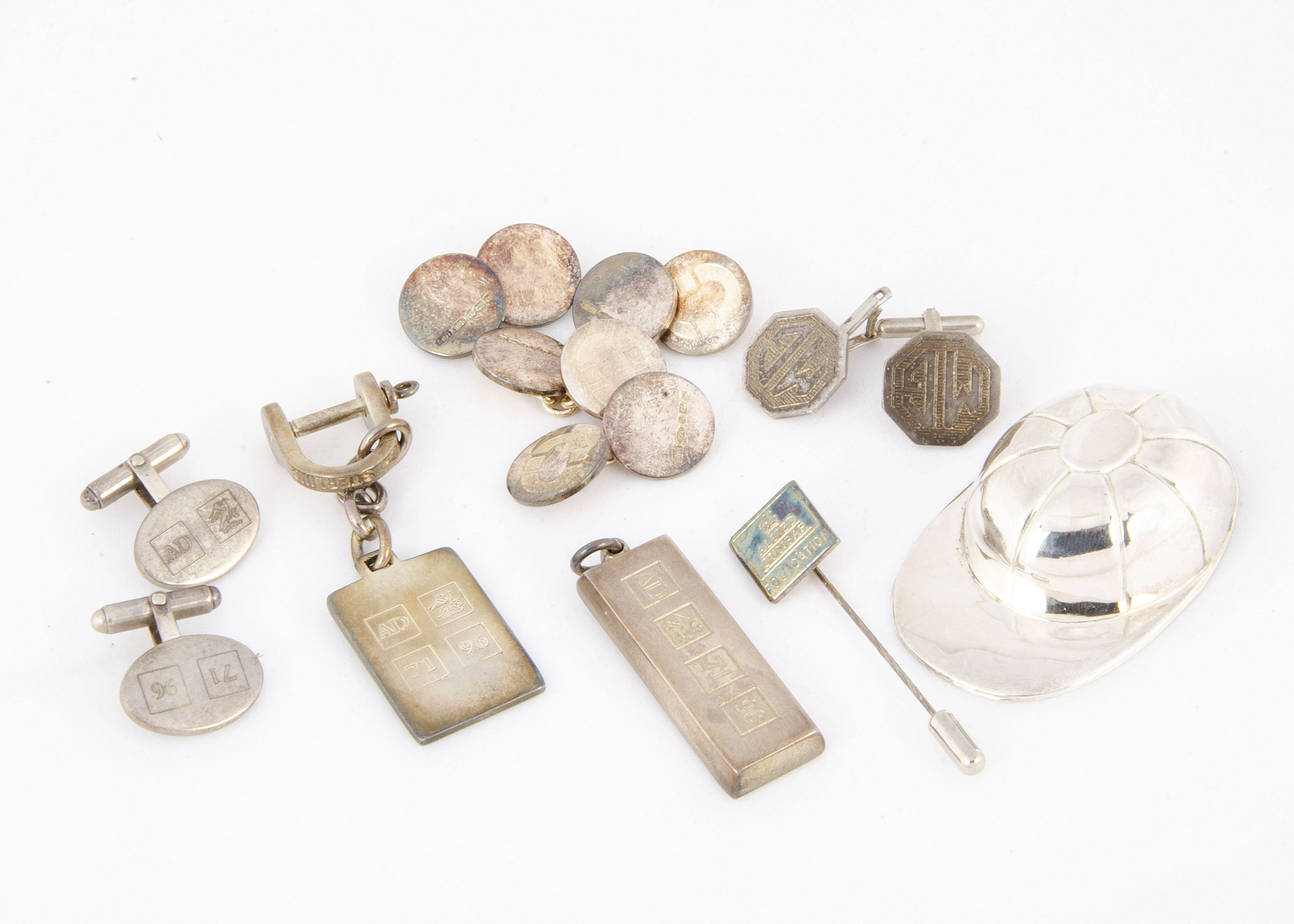 A modern silver jockey cap tea caddy spoon, together with a pair of silver MG cufflinks, an Allied