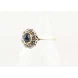 A continental sapphire and diamond cluster ring, all in yellow metal marked 750, with cabochon