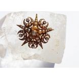 An Edwardian seed pearl and diamond brooch, of star design with sickle moons centred with old cut