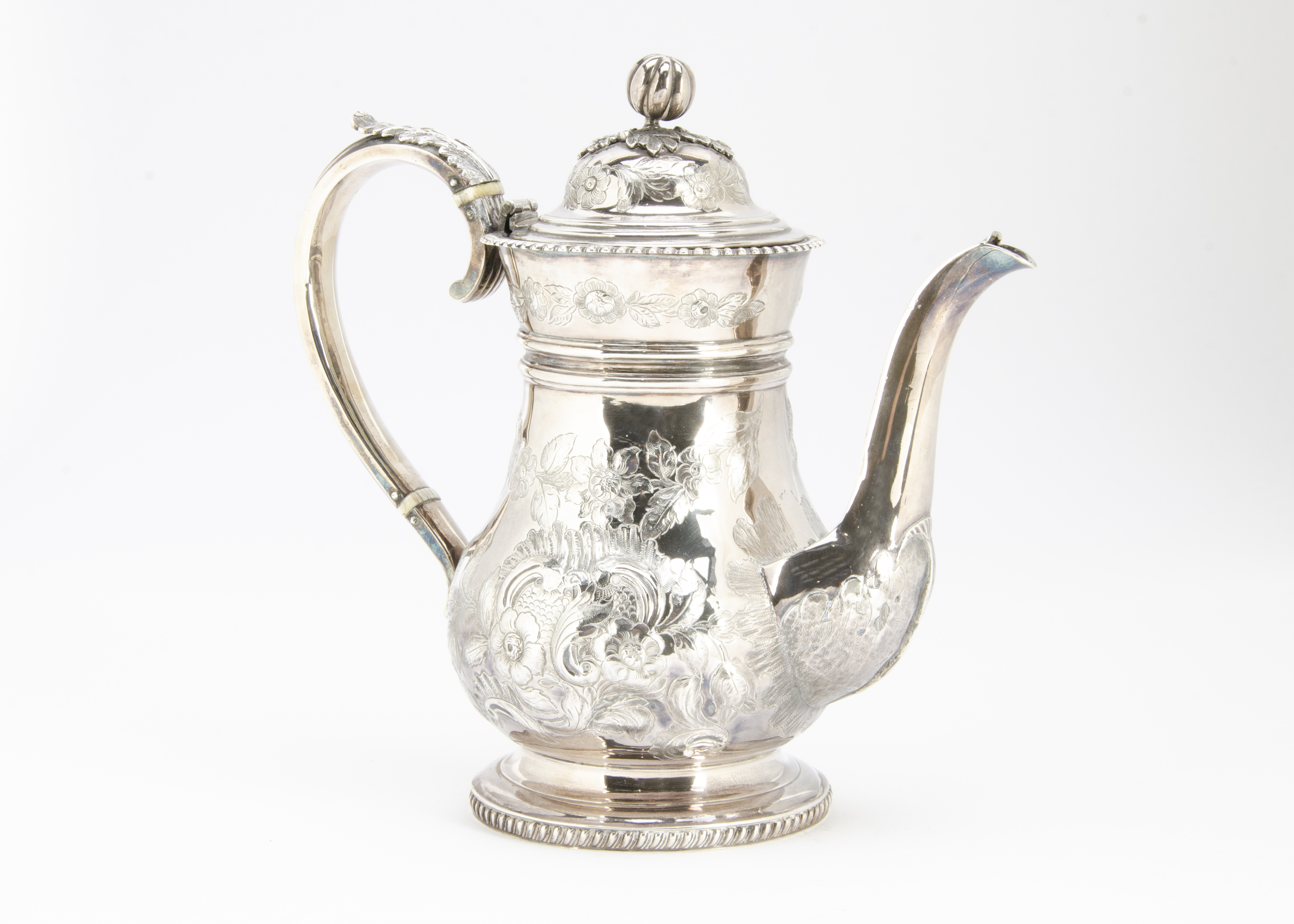 A 19th Century white metal coffee pot, bulbous body with raised floral designs, applied handle