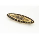 A 15ct gold oval shaped Victorian brooch, with central floral design within a sunken centre with