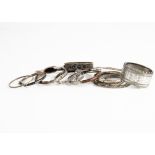 A collection of silver, white metal and base metal bangles, including an enamel and seed pearl