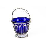 An Edwardian silver and glass swing handled bon bon dish, pierced basket supporting a blue glass