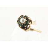 A Chinese jade dress ring, the oval cabochon jade set within four claw silver gilt leaf decorated