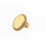 A Persian coin set yellow metal ring, the lion and sun gold coin within a filigree border and mount,