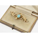 An Edwardian 15ct gold turquoise and seed pearl brooch, of scroll design marked 15ct to back, in