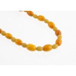 A string of Baltic amber and vegetable ivory beads, the oval amber beads alternately strung with