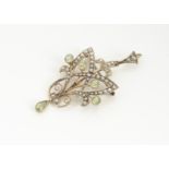 An Edwardian peridot and seed pearl 9ct gold pendant or brooch, in the Art Nouveau style, the