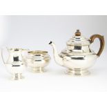 A George V silver three piece tea set from S Ltd, Birmingham 1930, comprising teapot, sugar basin