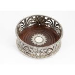 A 19th Century silver wine bottle coaster, the pierced sides with acanthus and other leaves, the