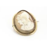 A 19th Century shell carved cameo brooch, the carving depicting a Greek warrior and his Queen, on