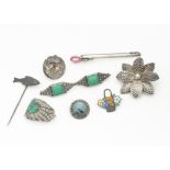 A collection of silver jewels, including an Arts and Crafts pebble brooch with pewter mount, a