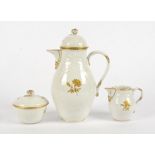 An early 20th Century Meissen three piece coffee set, with gilt floral decoration on a white ground,
