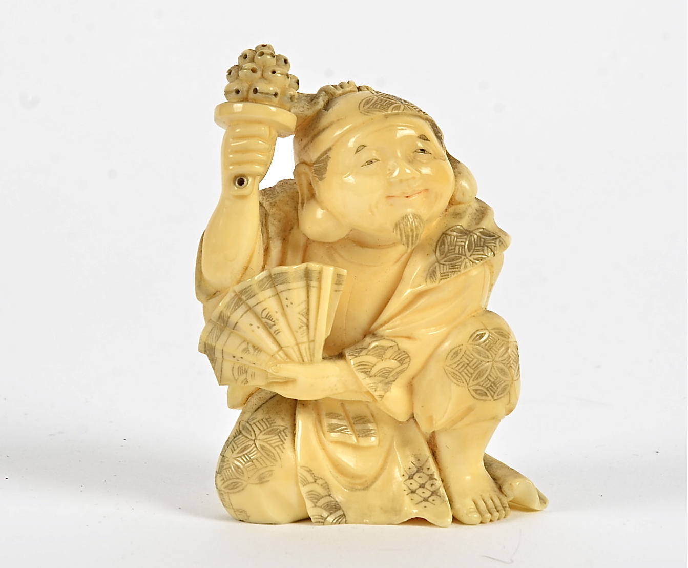 A seated Japanese Meiji period gentleman, holding a fan, artist's marks to base, height 8cm