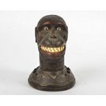 A Black Forest carved wooden monkey's head, with glass eyes, cut teeth and a hinged jaw, possibly