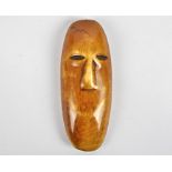 A Lega ivory mask, Congo, coloured with dark patina, modelled as a face, length 11cm