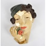 An Art Deco plaster wall pocket, in the form of a fahionable woman's head with a rose clutched to