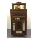 A walnut Edwardian music cabinet, a gallery mirrored back with turned supports, carved and