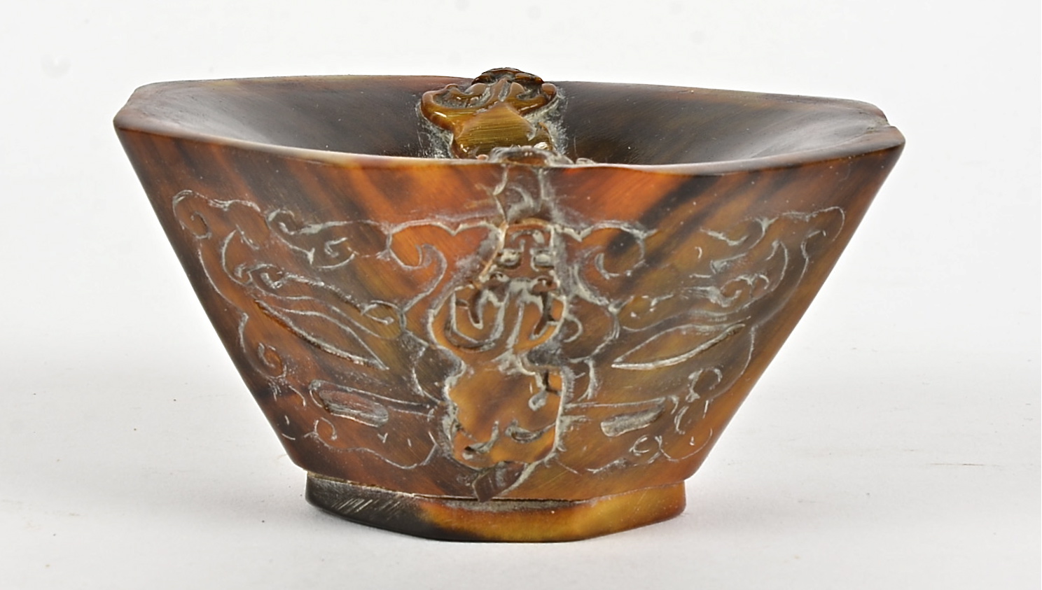 A 19th Century Chinese rhinoceros horn libation cup, the design comprising four mythical beasts